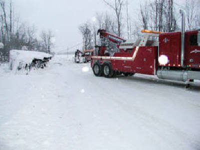 Severe winter storm recovery of a rolled over tractor and trailer